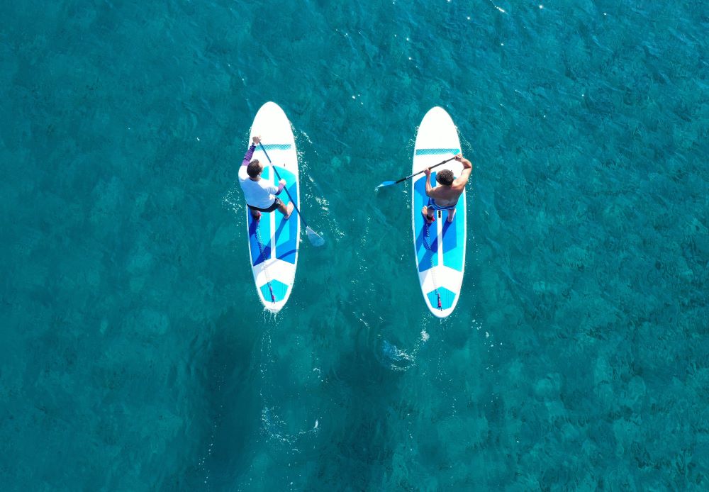 Aerial drone ultra wide photo of 2 men standing on a paddle board