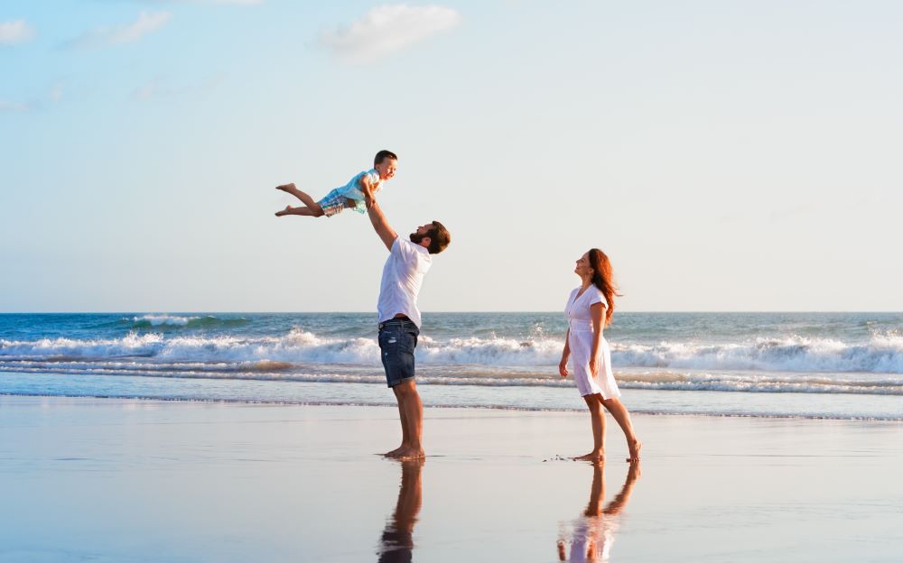Family with a small child having fun on a beach